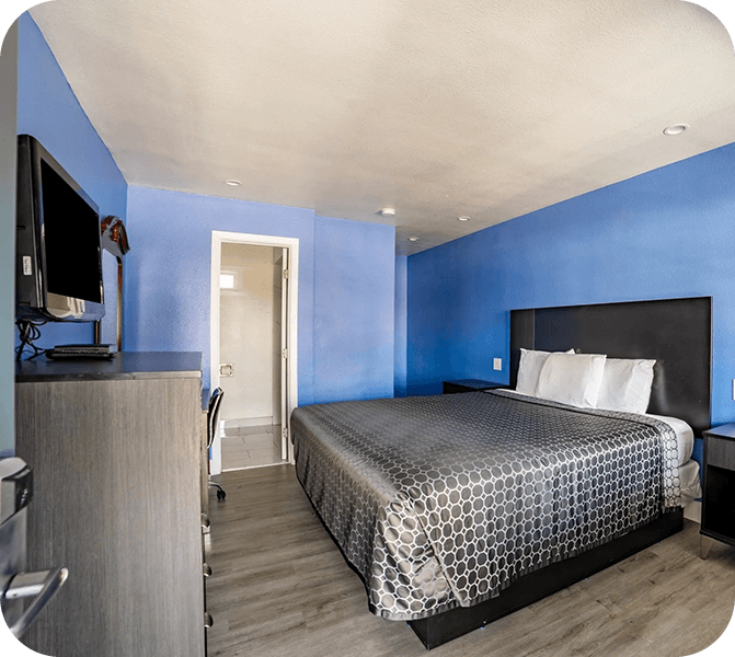 A bedroom with blue walls and a bed.