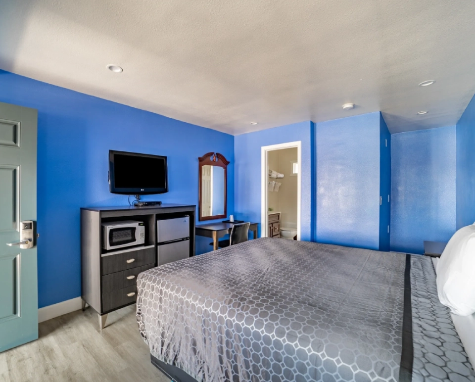 A bedroom with blue walls and a bed